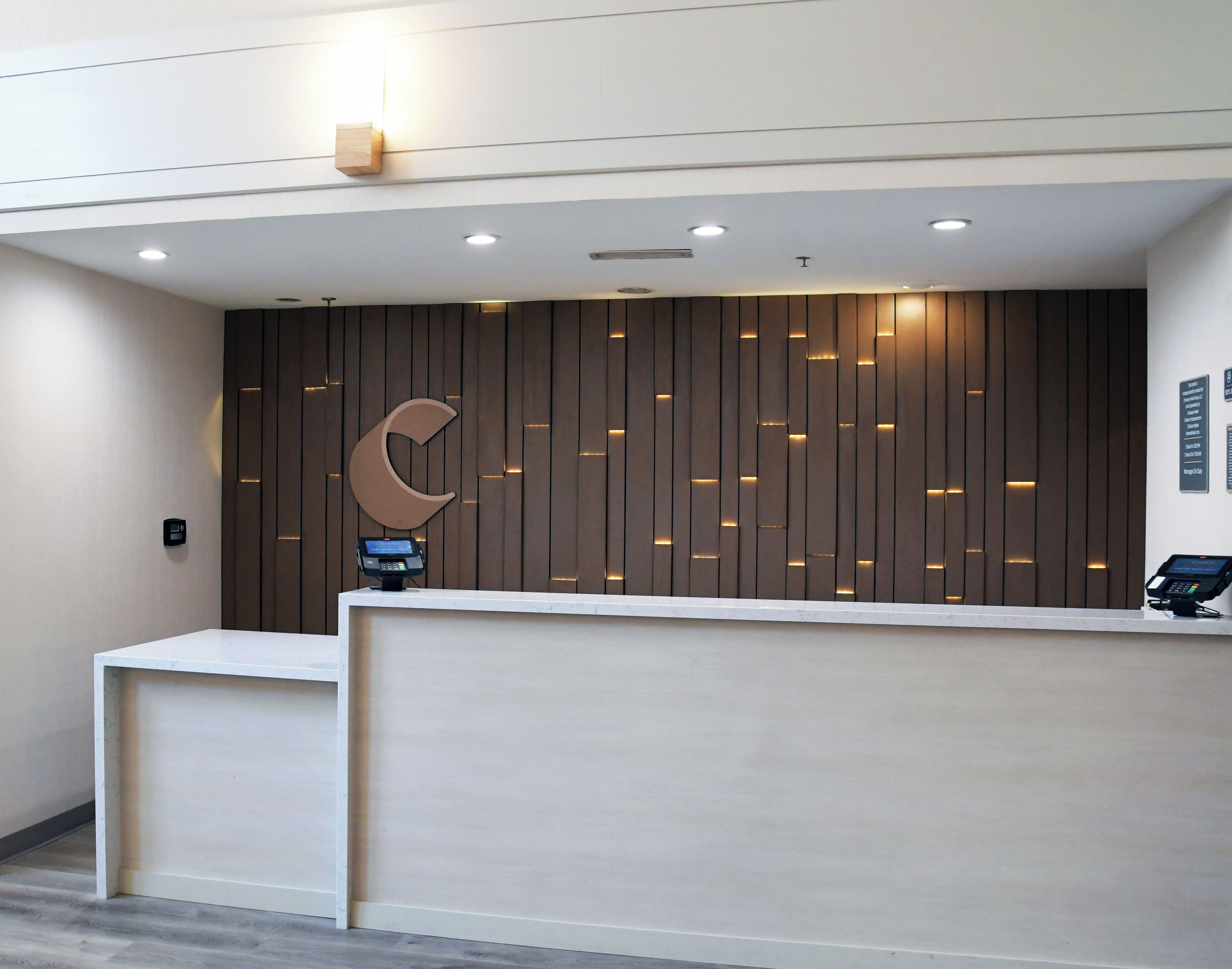 A reception desk with a modern design, featuring a wooden panel wall and a large crescent moon logo.