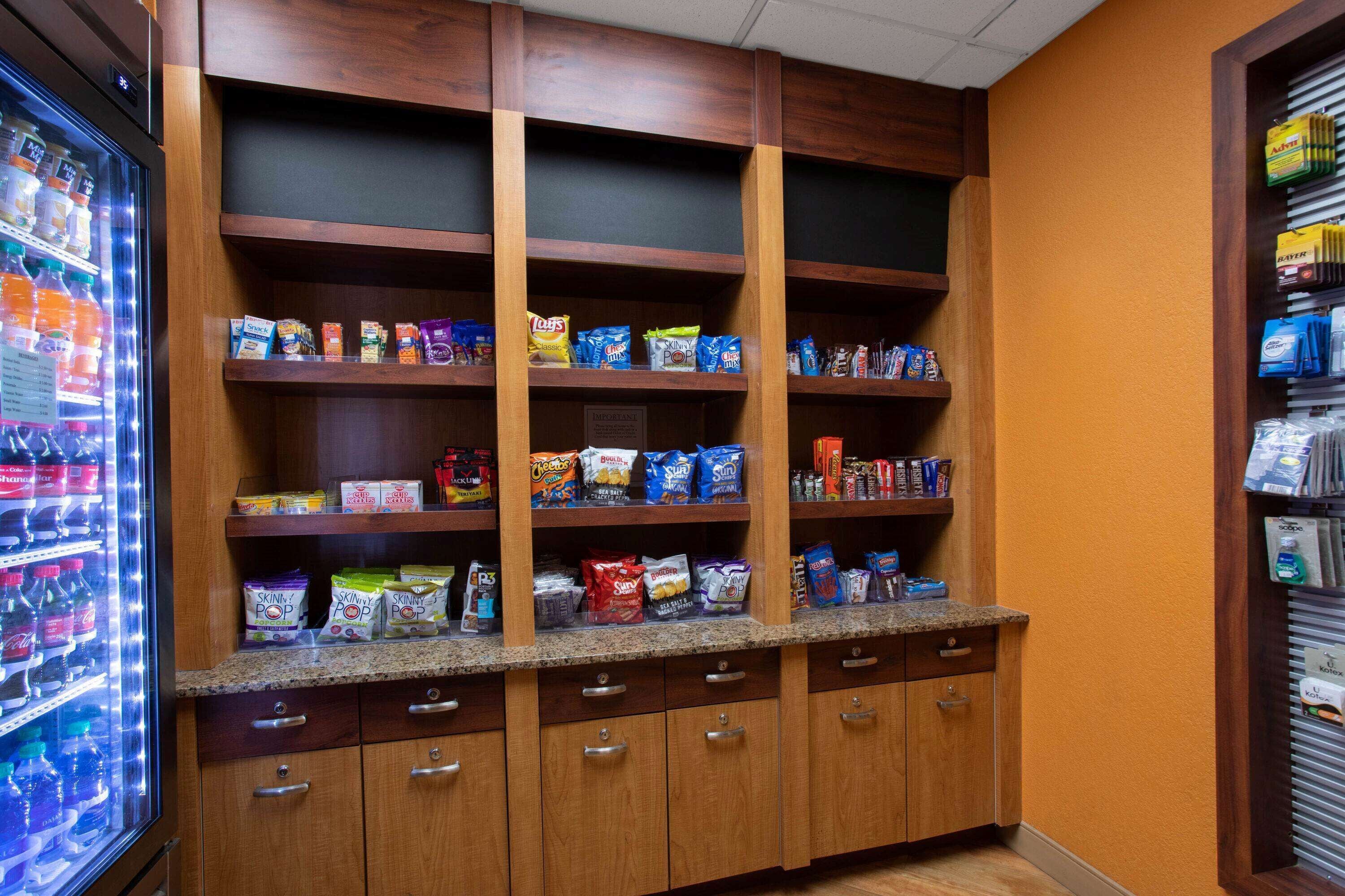 Een automaat met snacks en drankjes, met meerdere planken vol diverse producten.