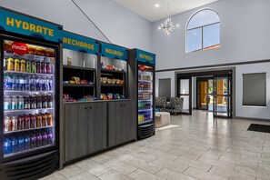 A modern lobby with hydration stations, seating, and a chandelier. - Clarion Pointe Hinesville near Fort Stewart (Hinesville)