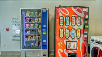 A vending machine with snacks and a soda dispenser, a soap dispenser, and a washing machine.