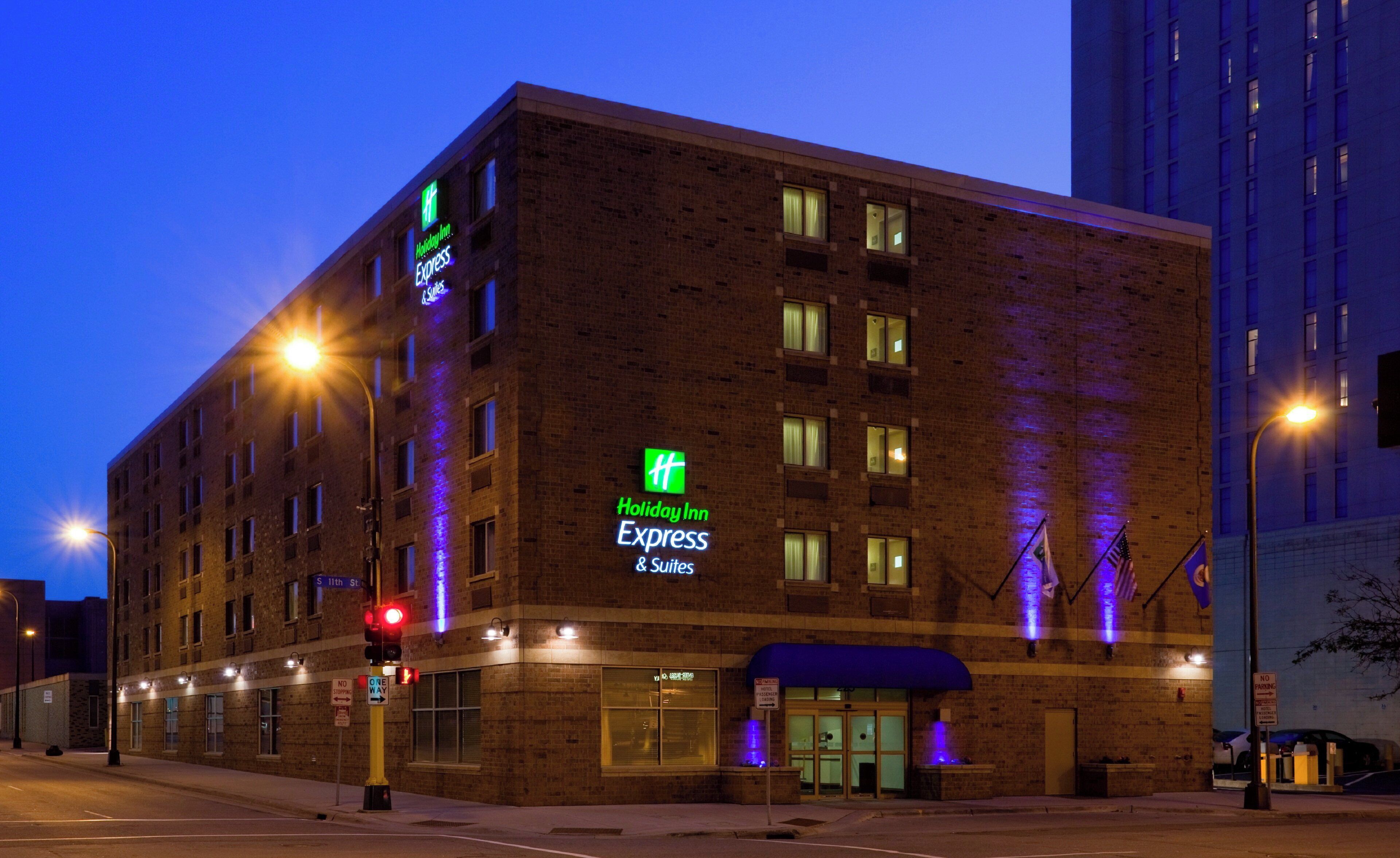 A Holiday Inn Express building with a brick facade, illuminated signage, and a blue awning.