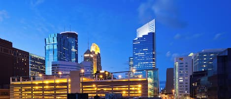 A cityscape with modern buildings and a parking area.