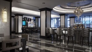 A modern bar area with a bar counter, multiple stools, and a chandelier. - Silversmith Hotel Chicago Downtown (Chicago)