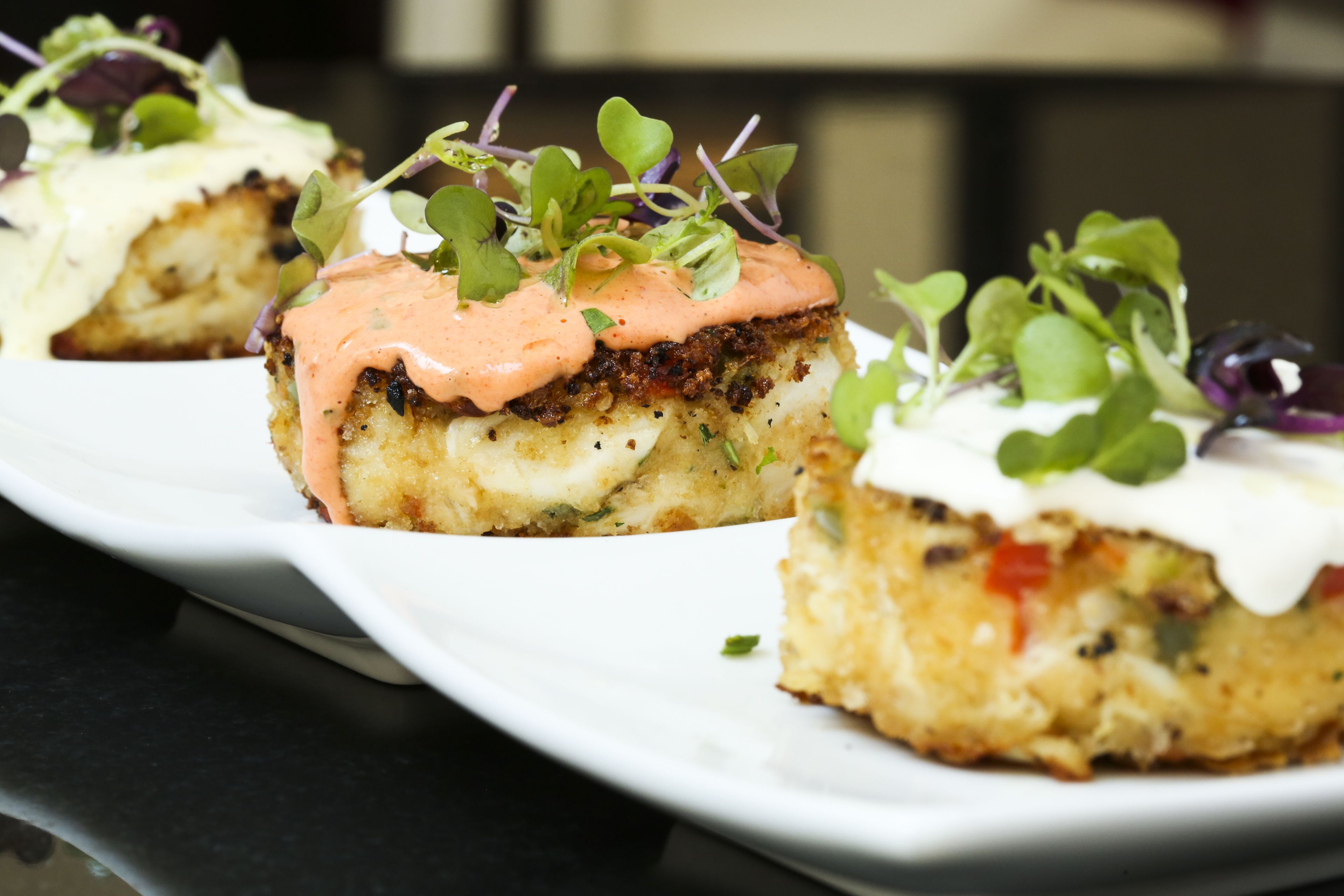 Un plato de comida con salsa cremosa y vegetales verdes.
