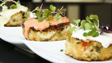 Un plato de comida con salsa cremosa y vegetales verdes.