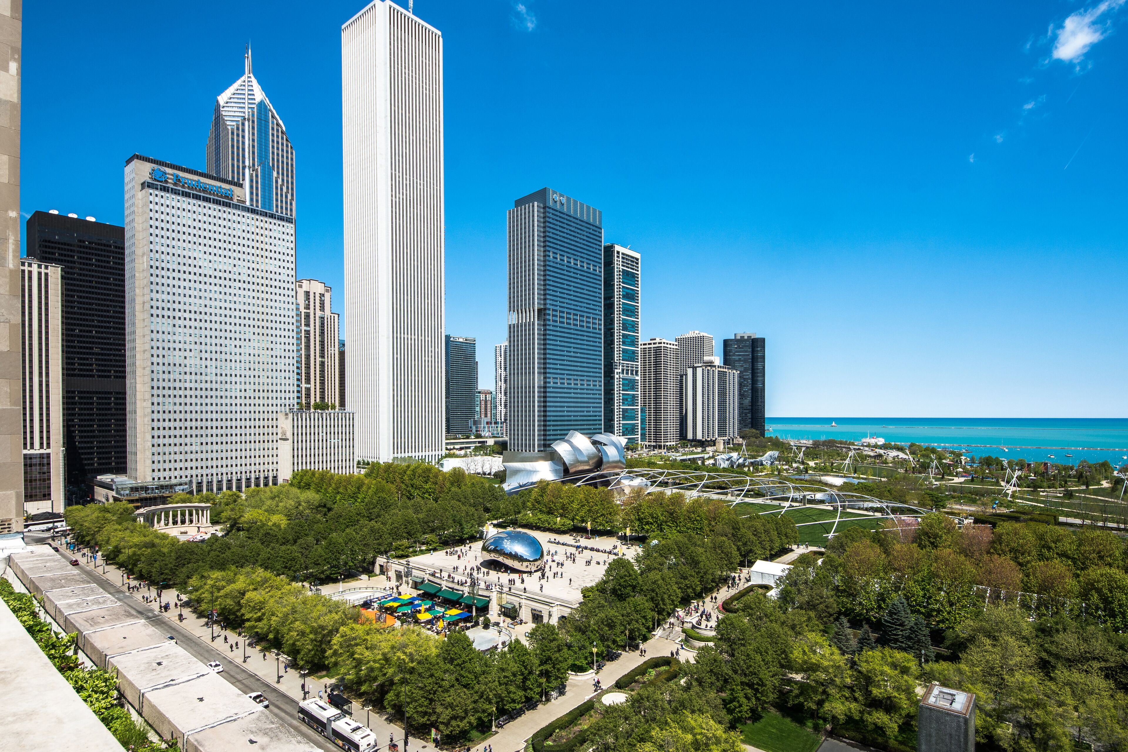 A cityscape with modern skyscrapers, a central plaza with a dome structure, and a waterfront.