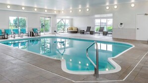 An indoor swimming pool with a clear view of the sky through large windows, surrounded by lounge chairs and a seating area. - Residence Inn by Marriott Denver North-Westminster (Westminster)