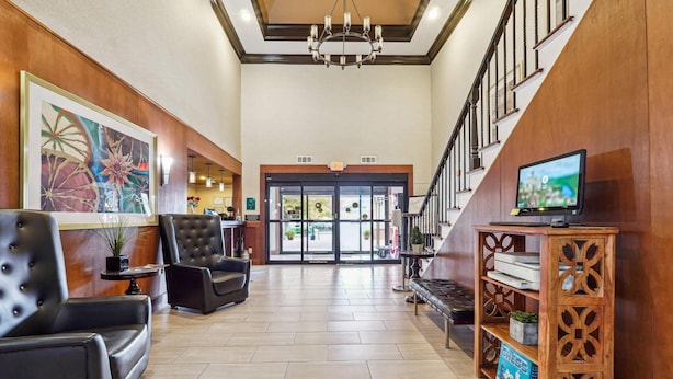 A spacious lobby with leather seating, a chandelier, and a wooden console with a television. - Quality Inn & Suites Dawsonville (Dawsonville)