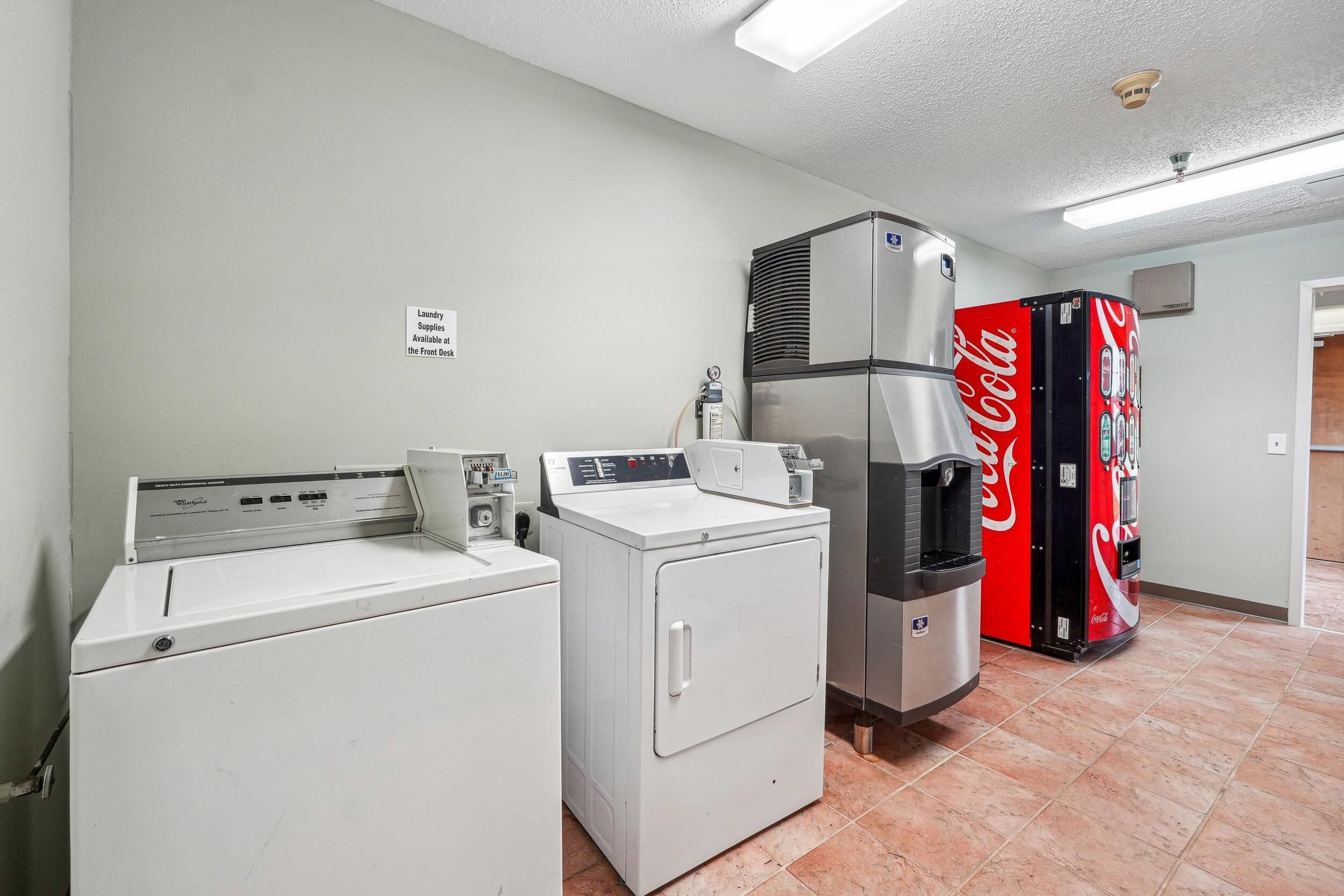 A laundry area with a front-loading washer, a top-loading dryer, and a water heater.