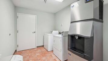 Una cocina compacta con refrigerador, lavadora y microondas.