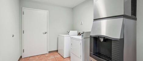 Una cocina compacta con refrigerador, lavadora y microondas.