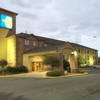 Un hotel con un cartel grande, un estacionamiento y un edificio con el número 5845.