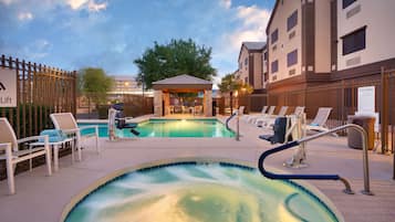 Una piscina al aire libre, sillones reclinables de piscina