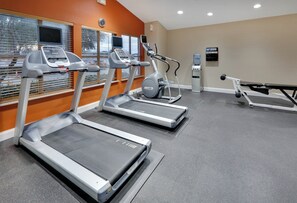 A gym with treadmills, a stationary bike, and a bench press. - Candlewood Suites Market Center by IHG (Dallas)