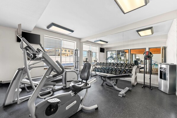 A gym with exercise equipment, a water dispenser, and a mirror. - Country Inn & Suites by Radisson Kenosha - Pleasant Prairie (Kenosha)