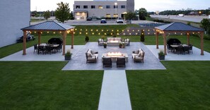 An outdoor patio area with seating and a fire pit, surrounded by string lights. - Country Inn & Suites by Radisson Kenosha - Pleasant Prairie (Kenosha)