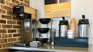 A kitchenette with a coffee machine, a coffee grinder, and a coffee maker. There are also two containers and a basket on the counter. - Motel 6 Hillsville, VA (Hillsville)