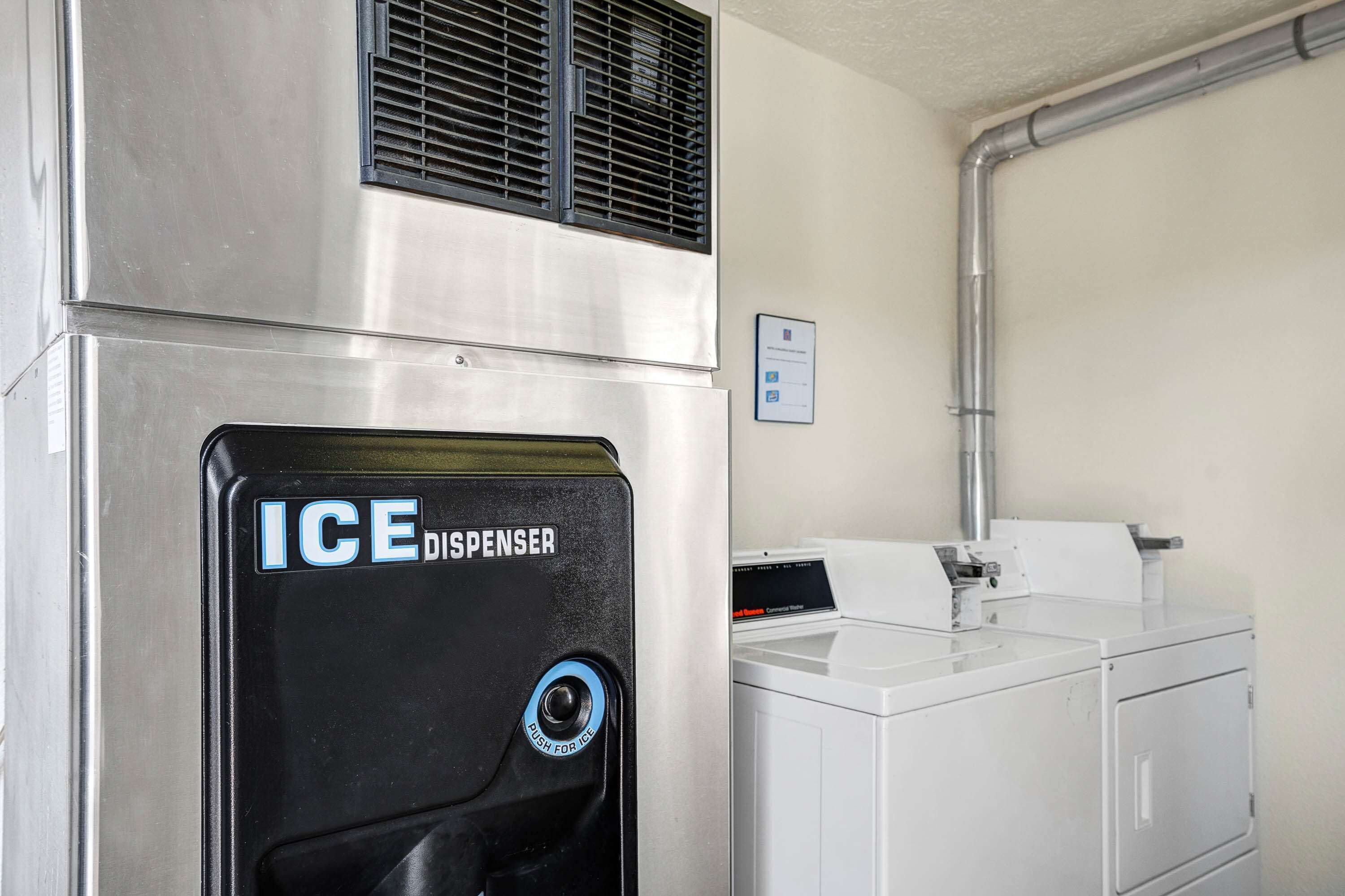 A laundry area with an ice dispenser and a washing machine.