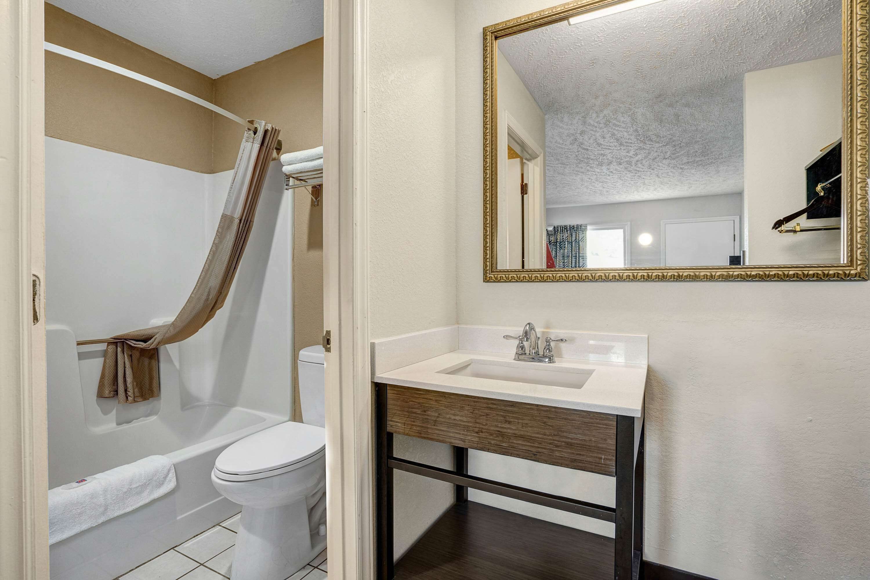 A bathroom with a bathtub, toilet, and sink.