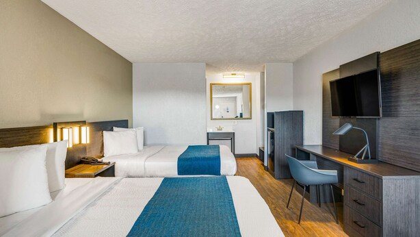 A hotel room with two beds, a desk, a chair, a TV, and a bathroom visible in the background. - Motel 6 Hillsville, VA (Hillsville)
