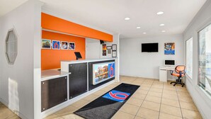 A reception area with a desk, a computer, and a TV on the wall. - Motel 6 Hillsville, VA (Hillsville)