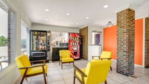 A modern interior with yellow chairs, a vending machine, and a kitchen area. - Motel 6 Hillsville, VA (Hillsville)
