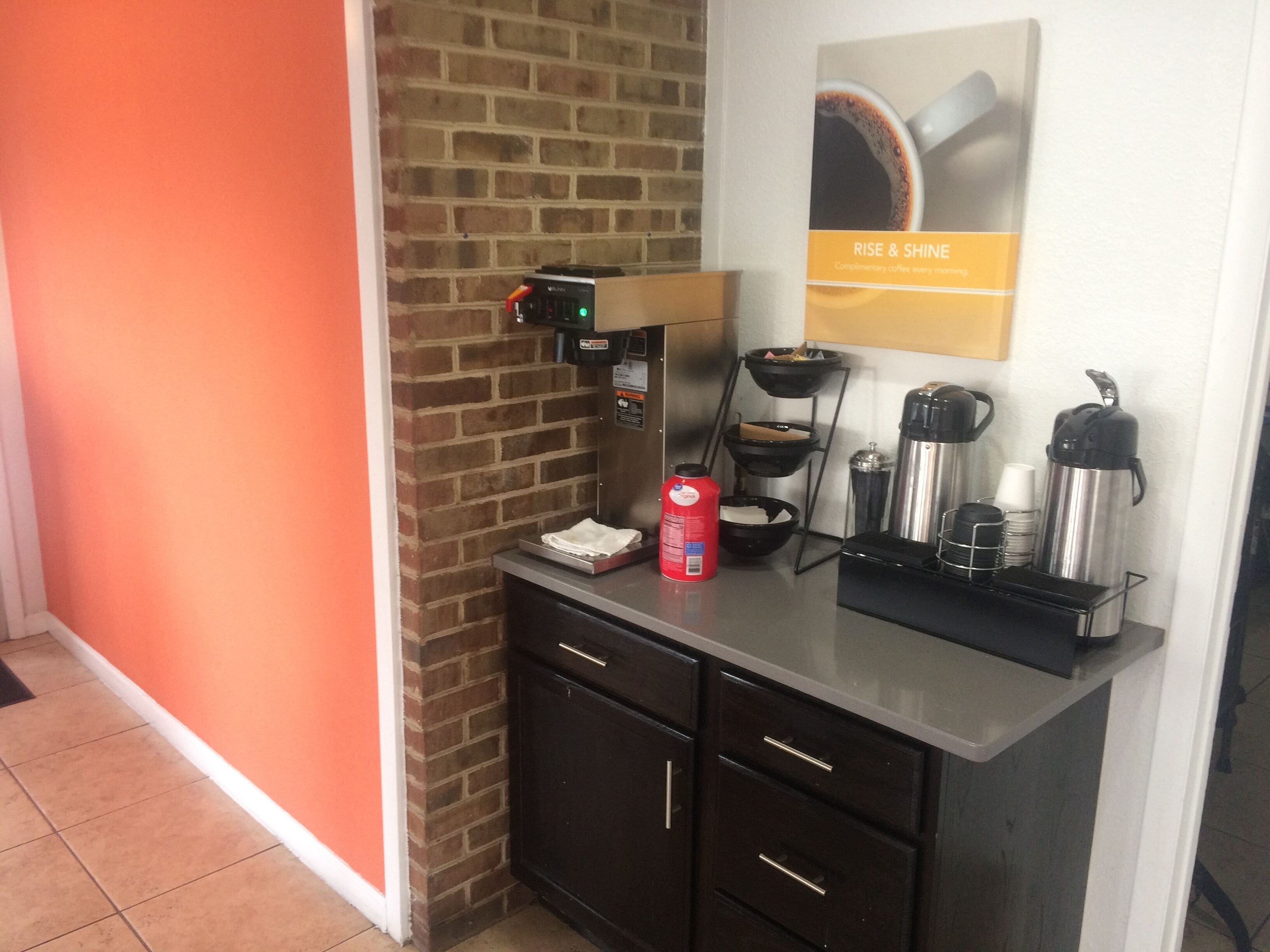 Una cuina americana equipada amb cafetera, búl i dispensador de cafè.