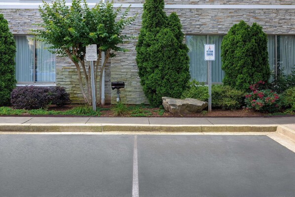 Un edificio con fachada de piedra, un buzón y un cartel que indica 'Veteran Parking'.