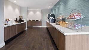 Een moderne keuken met houten kastjes, een wit aanrecht en een betegelde spatwand.