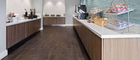 A modern kitchen with wooden cabinets, a white countertop, and a tiled backsplash.