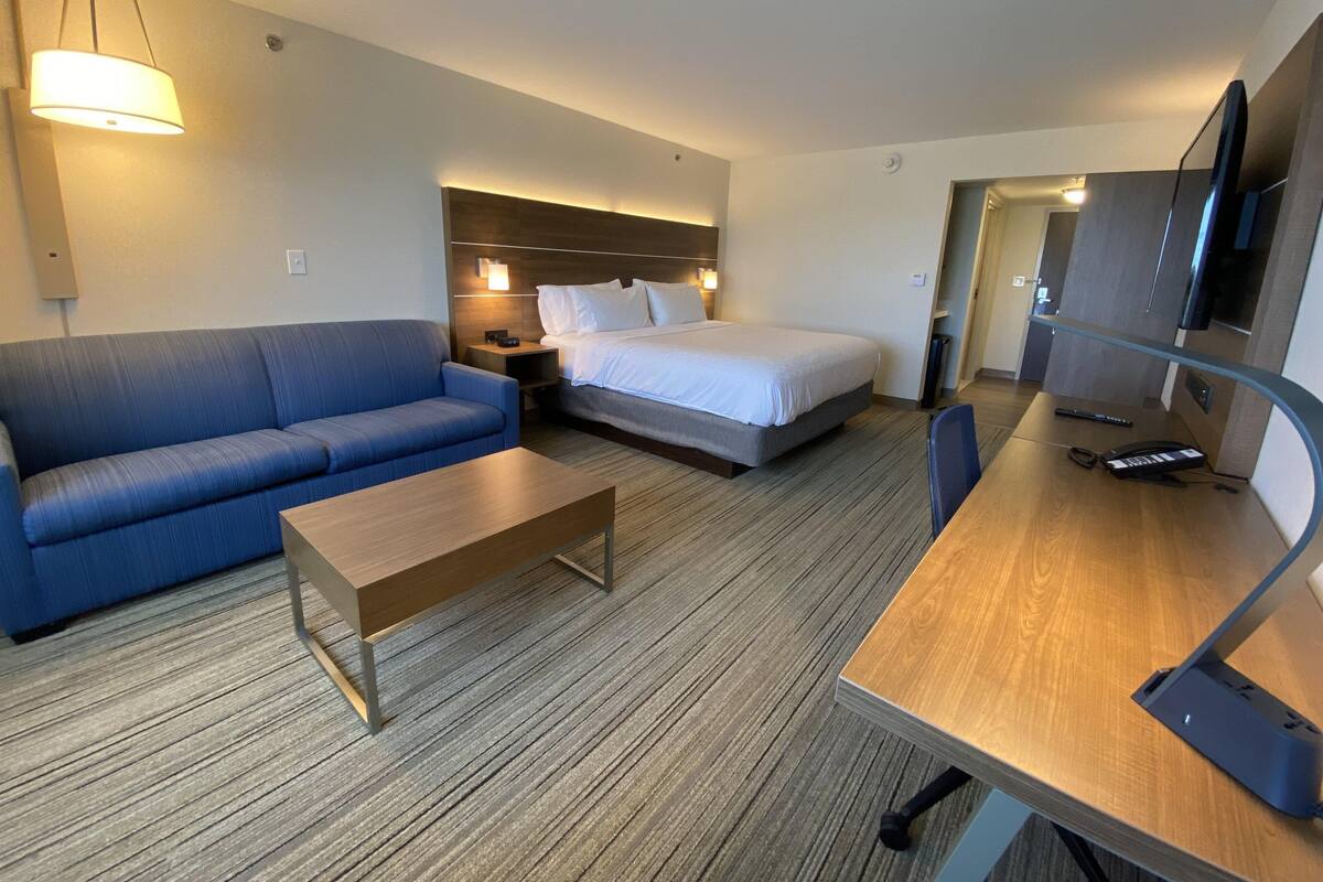 Een hotelkamer met een bed, een bank, een bureau en een televisie.