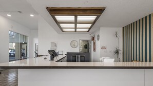 Un espace d’accueil au design moderne, comprenant un comptoir, une horloge et un panneau affiché sur le mur.