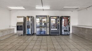 Une rangée de distributeurs automatiques dans une pièce propre, carrelée, dont l’aménagement est simple.