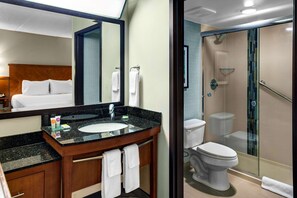 A hotel bathroom with a marble sink, a large mirror, a glass-enclosed shower, and a toilet. - Hyatt Place Albuquerque Airport (Albuquerque)