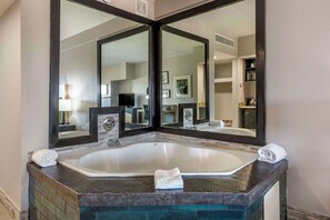 A bathroom with a large bathtub, a double mirror, and a towel rack.