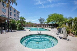 A swimming pool with a circular design, surrounded by lounge chairs and palm trees. - Country Inn & Suites by Radisson, Mesa, AZ (Mesa)
