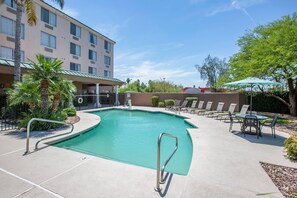 A swimming pool with a poolside area, lounge chairs, and a building in the background. - Country Inn & Suites by Radisson, Mesa, AZ (Mesa)