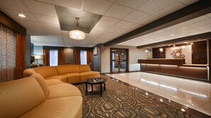 A hotel lobby with a reception desk, a sofa, and a patterned carpet. - Best Western Plus Coldwater Hotel (Coldwater)