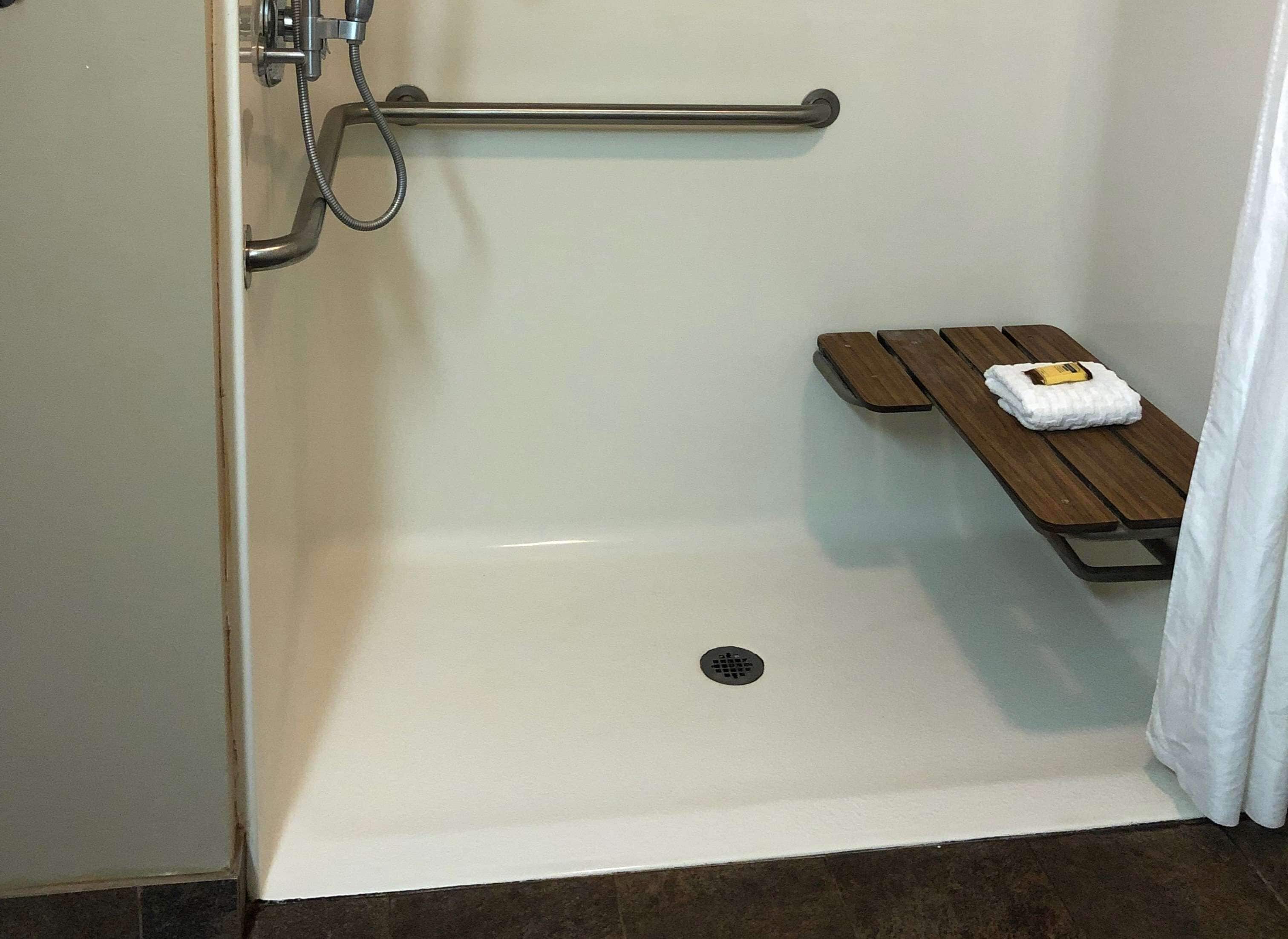 Un área de ducha con un banco y una toalla.