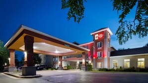 A hotel with a covered parking area, an American flag, and a sign indicating 'Best Western Plus' branding. - Best Western Plus Coldwater Hotel (Coldwater)