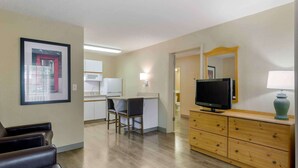 A hotel room with a kitchenette, a television, a desk with a chair, and a large mirror. - Extended Stay America Suites Nashville Franklin Cool Springs (Franklin)