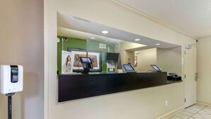 A reception area with a black counter, a digital kiosk, and a mounted television. - Extended Stay America Suites Nashville Franklin Cool Springs (Franklin)