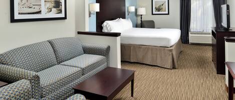 Una habitación de hotel con cama, sofá, escritorio y televisión.