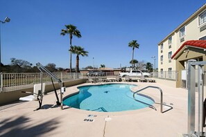 Una piscina al aire libre, sillones reclinables de piscina