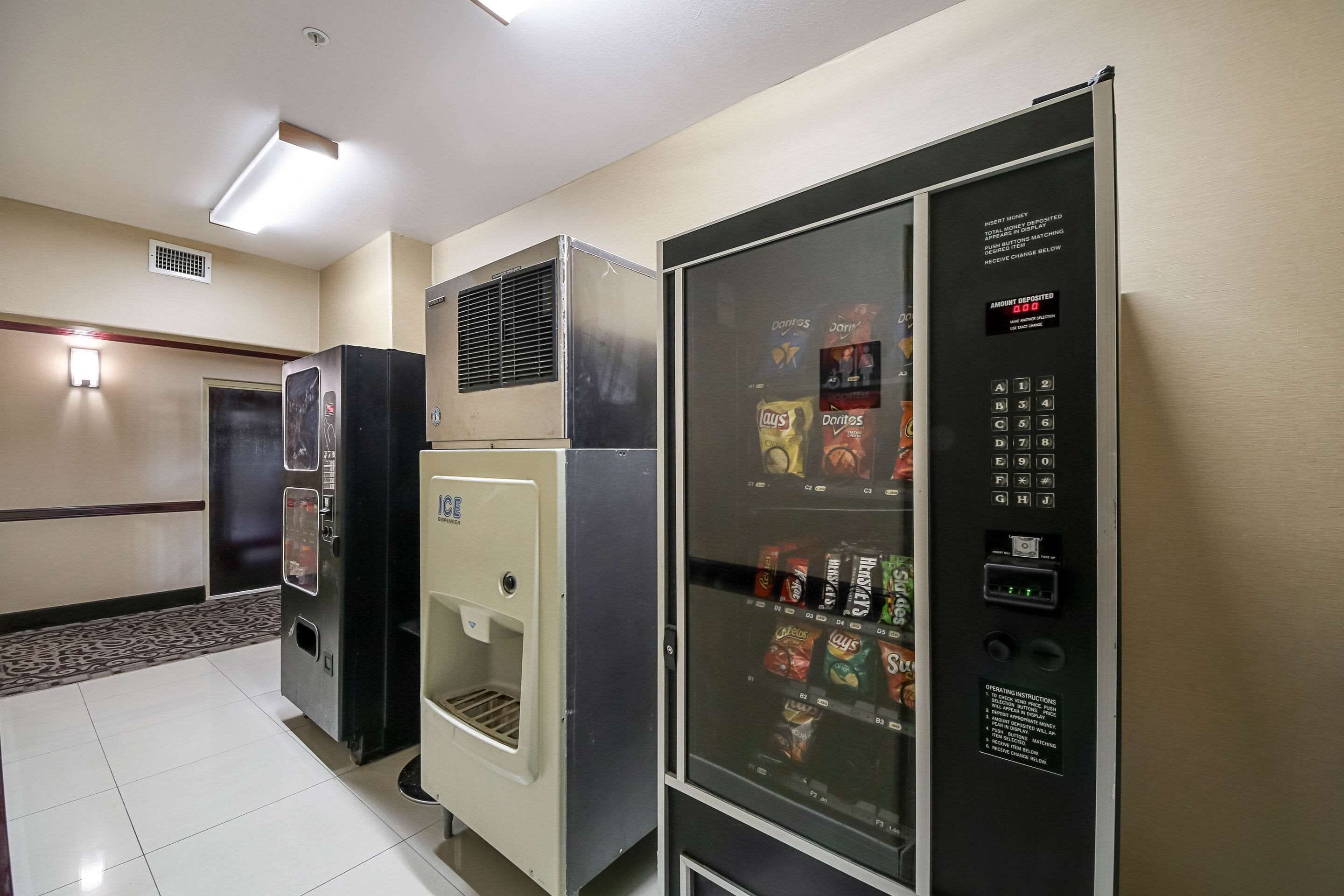 Una máquina expendedora con variedad de aperitivos y un cajero automático para depositar efectivo.