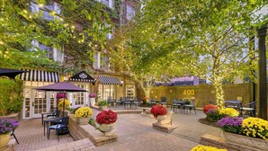 An outdoor patio area with brick flooring, outdoor seating, and potted plants. - Best Western Plus Hawthorne Terrace Hotel (Chicago)