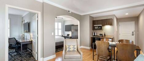 A modern living room with a dining area, a kitchen, and a bedroom.