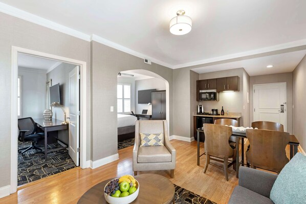 A modern living room with a dining area, a kitchen, and a bedroom.