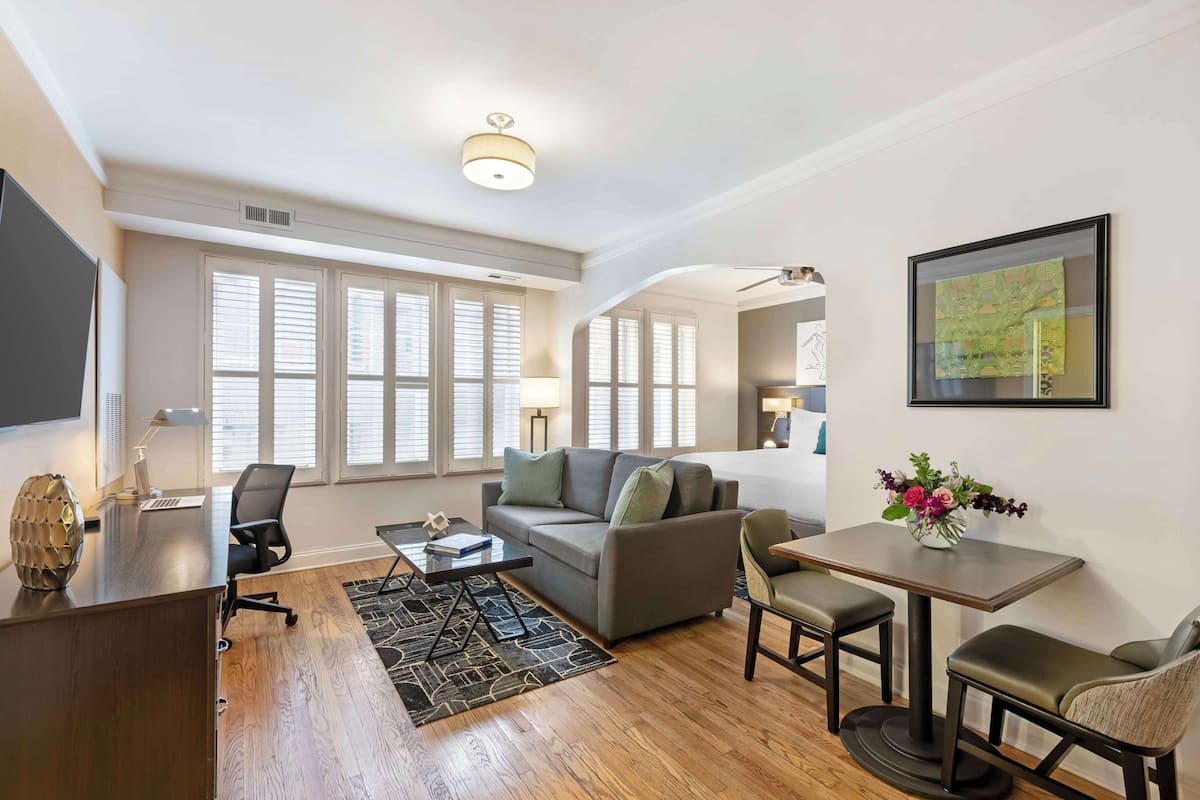 A modern living room with a sofa, a dining table, and a TV.