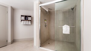 A modern bathroom with a glass-enclosed shower, a towel rack, and a shelf with folded towels. - Holiday Inn Express & Suites Scottsburg by IHG (Scottsburg)